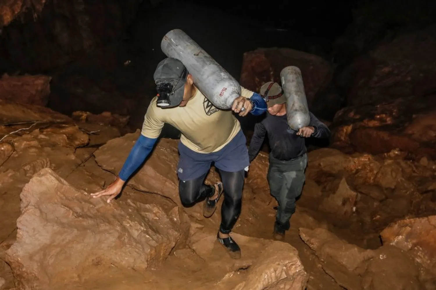 Thai rescue personnel carry oxygen tanks inside the Tham Luang cave during search operations to find the missing members of the children's football team along with their coach at the cave in Khun Nam Nang Non Forest Park in Chiang Rai, on June 26, 2018. PHOTO: AFP 