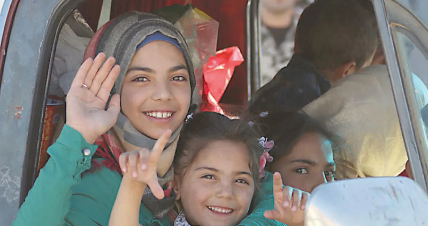 عائلة سورية في طريق العودة إلى بلدتها بعد مغادرة عرسال في البقاع اللبناني (أ.ف.ب)