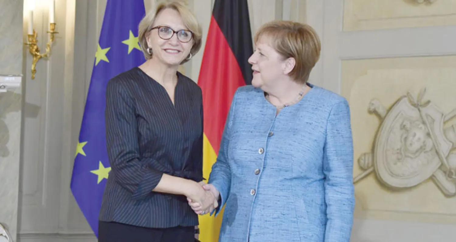 المستشارة الألمانية أنجيلا ميركل مع آن ماري ديسكوت سفيرة فرنسا في برلين (أ.ف.ب)