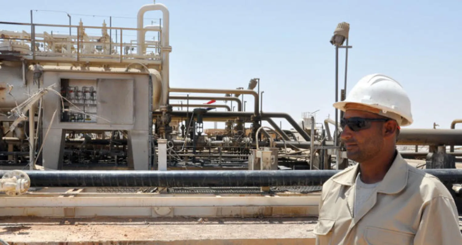 عامل يقف أمام منشأة في أحد حقول الغاز قرب تدمر (غيتي)