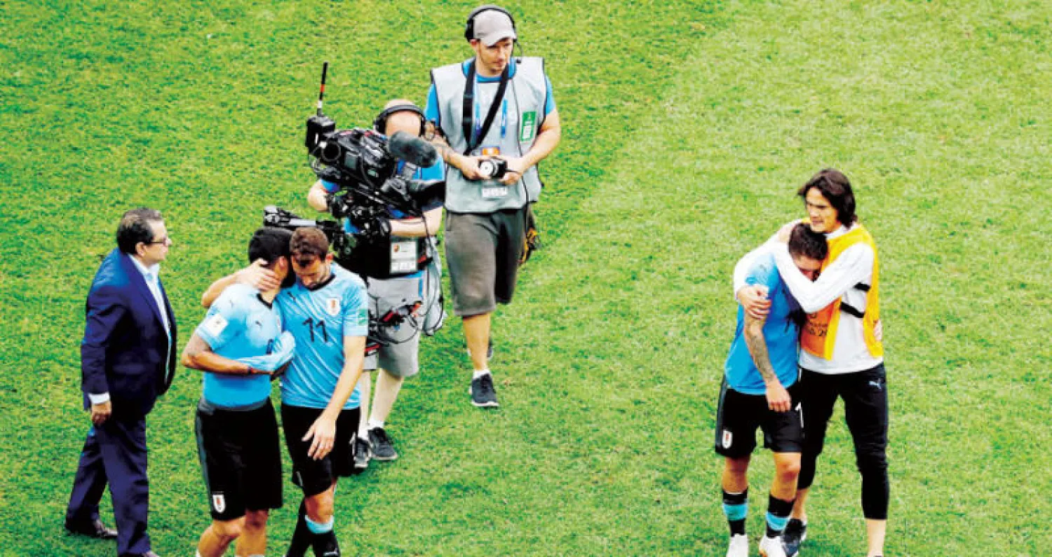 كافاني يواسي زملاءه بعد الخروج من المونديال (رويترز)