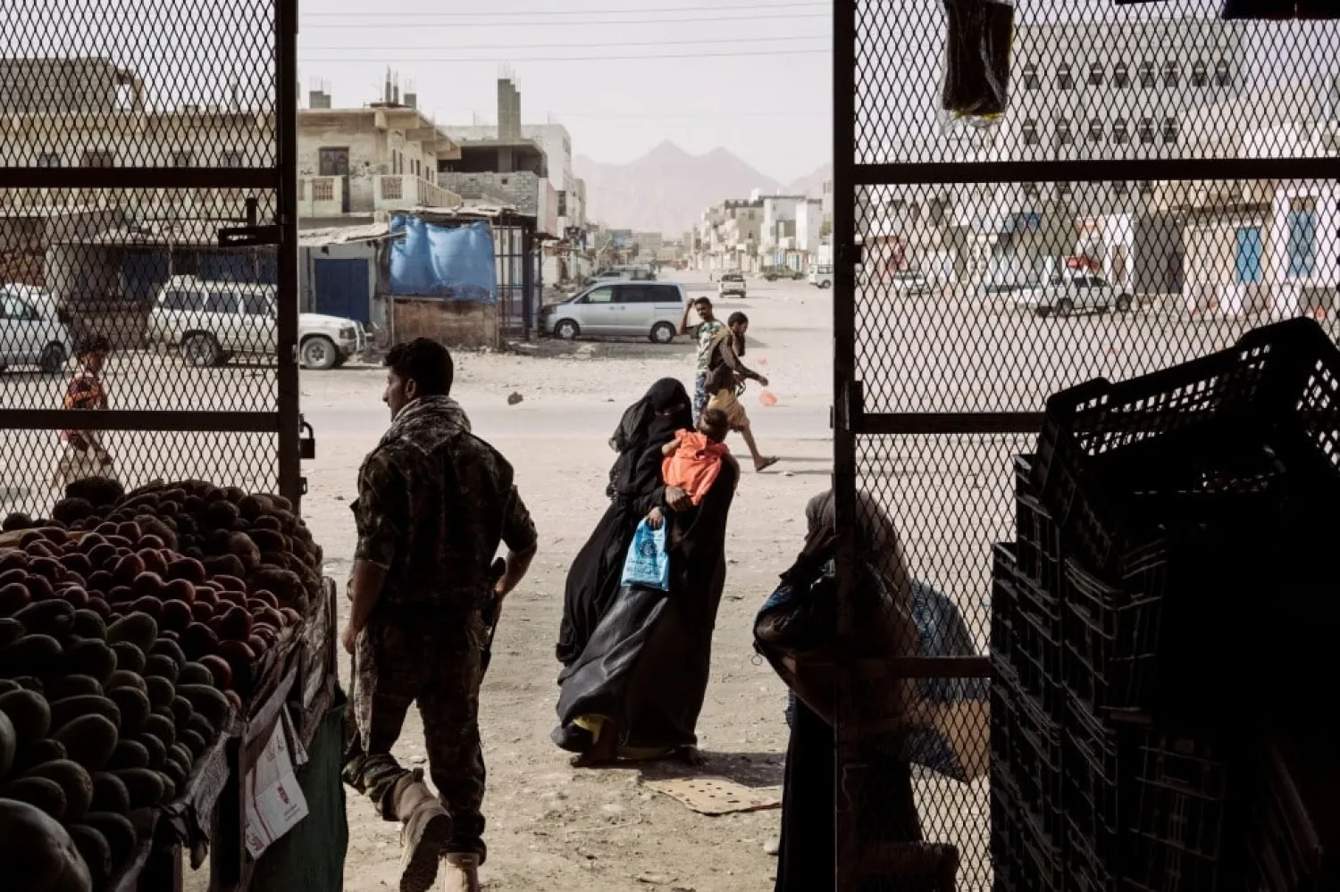  Mohammed Salim al-Buhar, left, commander of the Shabwani Elite Forces, walks outside a grocery in liberated Azzan.  via Washington Post 