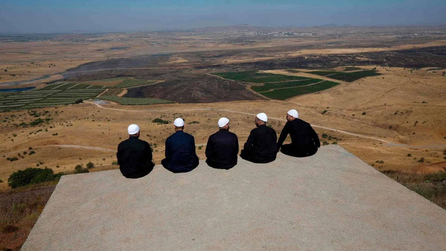 Druze men at the Israeli-annexed Golan Heights look out
across Quneitra. AFP