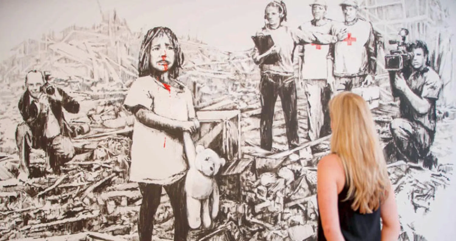 في معرض «بانكسي... أشهر الأعمال 2002-2008» الذي افتُتح أمس بغاليري لازينك في لندن (أ.ف.ب)