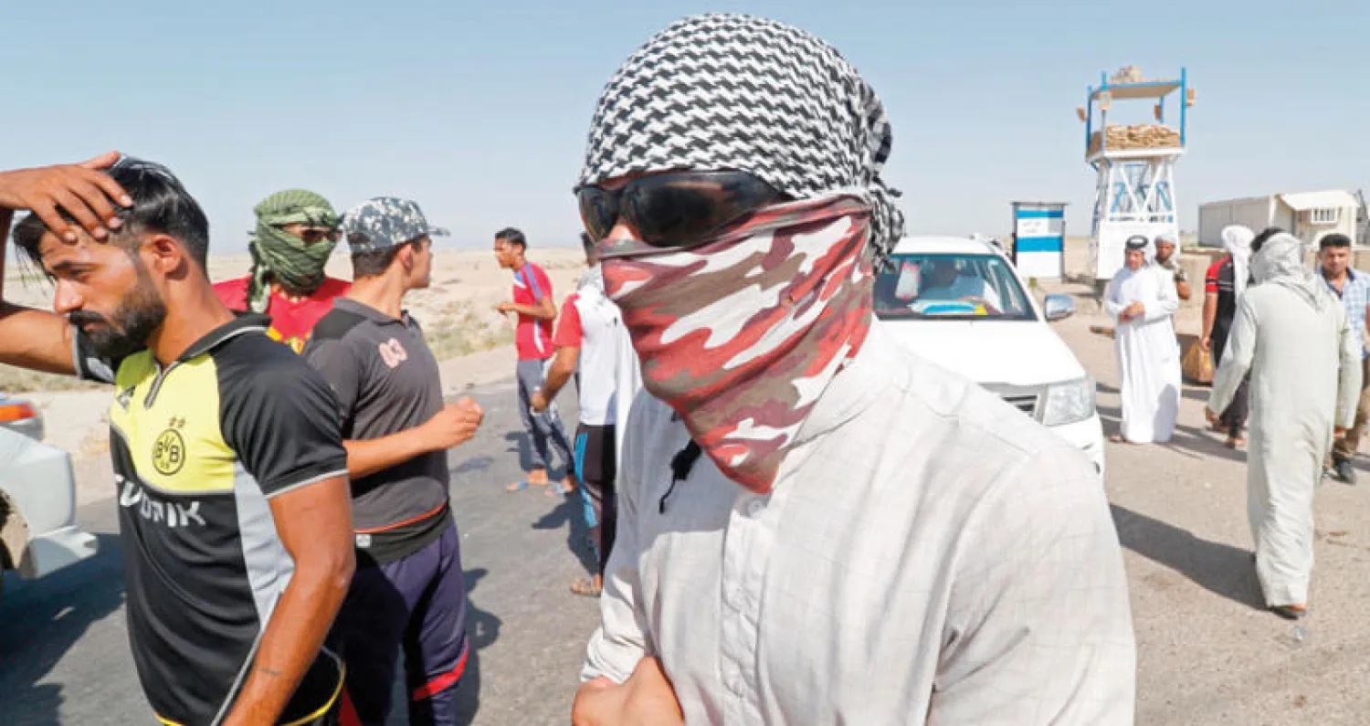 محتجون أمام حقل القرنة النفطي شمال البصرة أمس (أ.ف.ب)