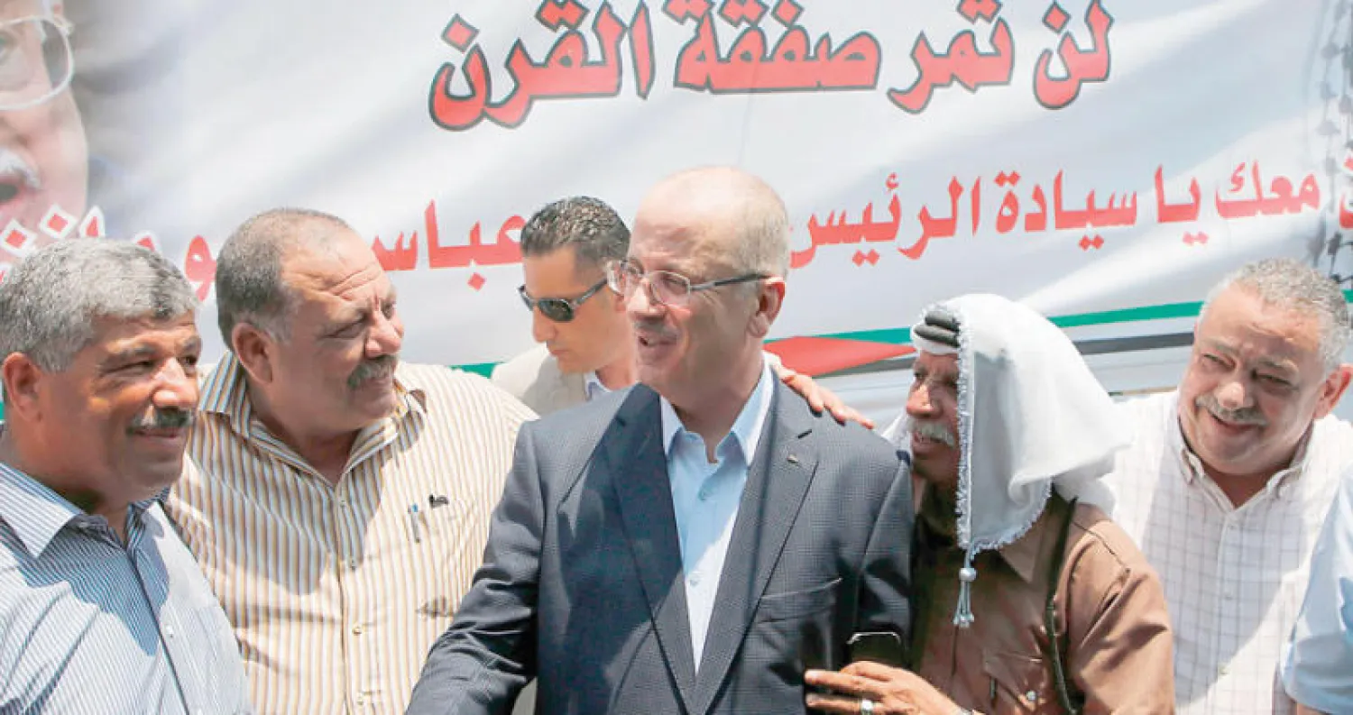 رئيس الوزراء الفلسطيني مع سكان في الخان الأحمر (أ.ف.ب)