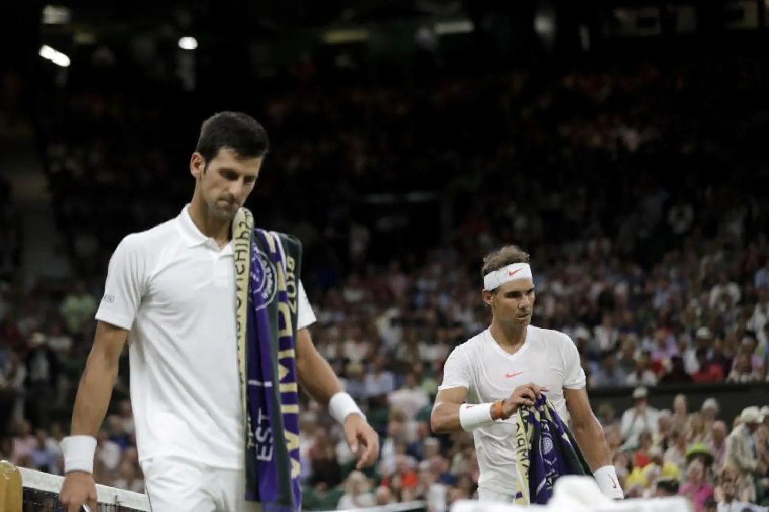 الصربي نوفاك ديوكوفيتش (يسار) والإسباني رافائيل خلال مباراة الدور قبل النهائي لبطولة «ويمبلدون» للتنس (أ.ف.ب)