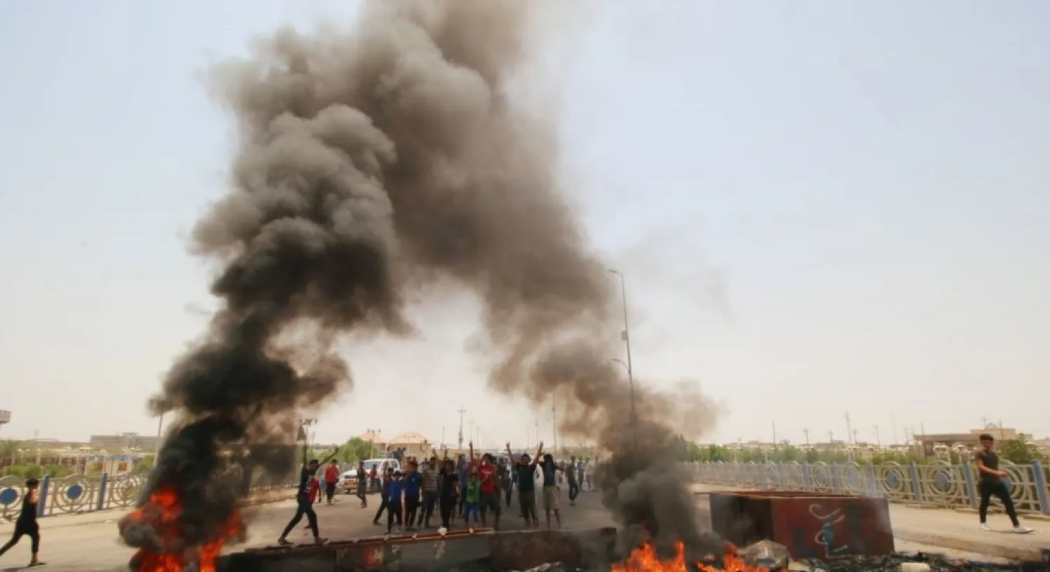 Iraqi protesters burn tires and block the road at the entrance to the city of Basra, Iraq. (Reuters)