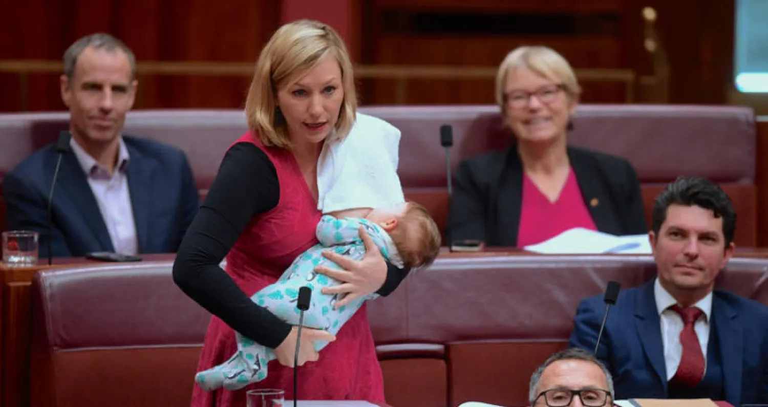 السيناتور الأسترالية لاريسا ووترز من حزب الخضر ترضع ابنتها في مبنى البرلمان في كانبيرا (رويترز)