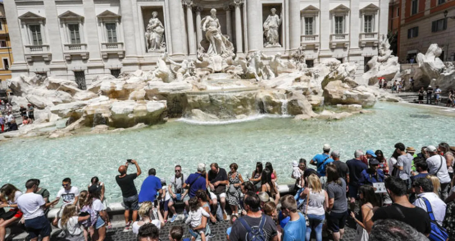 سياح بجوار نافورة تريفي الشهيرة في روما خلال يوم حار... وكانت وزارة الصحة الإيطالية قد أصدرت إنذاراً حرارياً لثماني مدن إيطالية خلال عطلة نهاية الأسبوع محذرةً من أن درجة الحرارة ستصل إلى 36 درجة مئوية (إ.ب.أ)