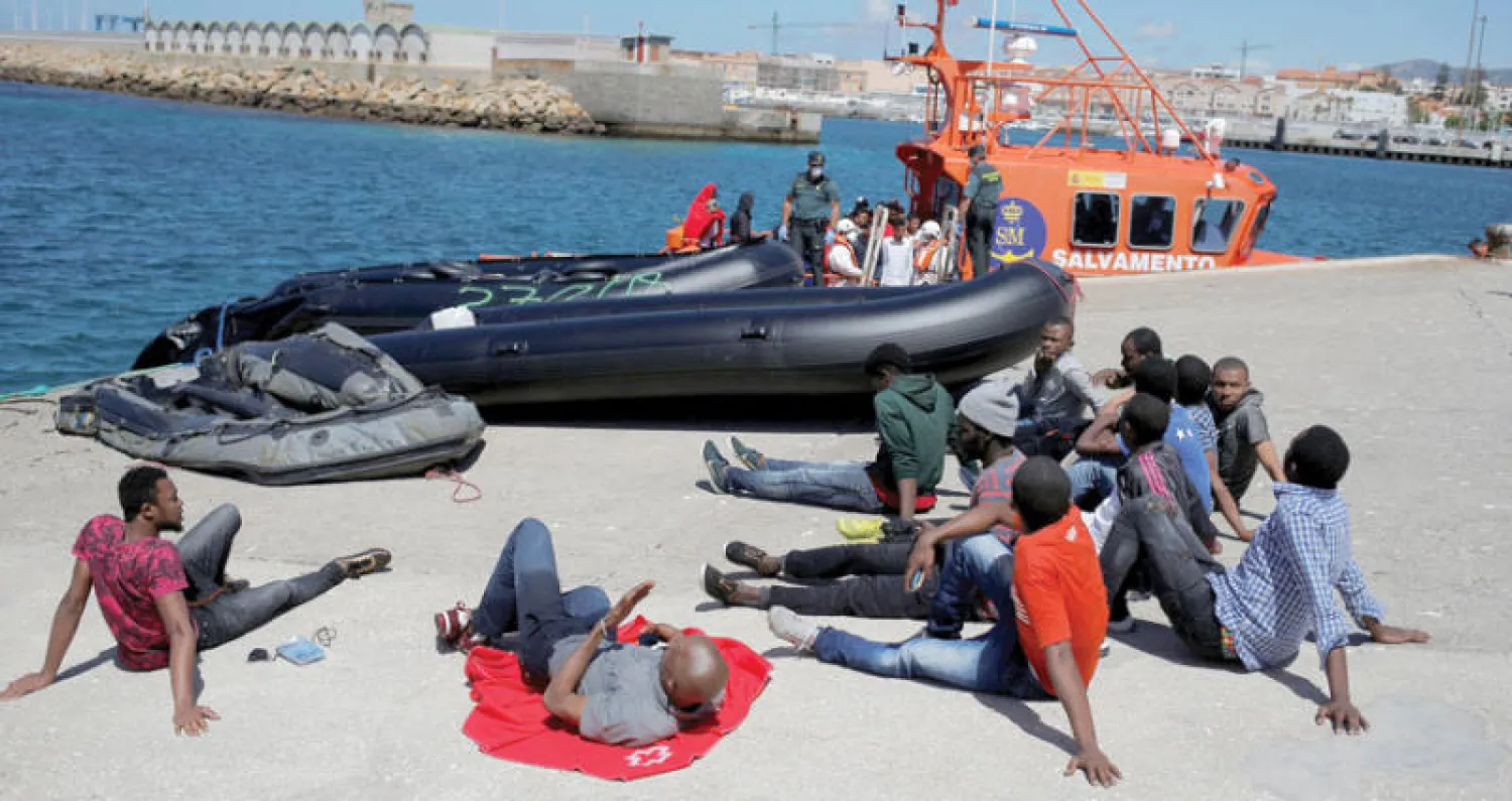 مهاجرون تم إنقاذهم في البحر الأبيض المتوسط بعد إنزالهم في ميناء طريفة الإسباني (رويترز)