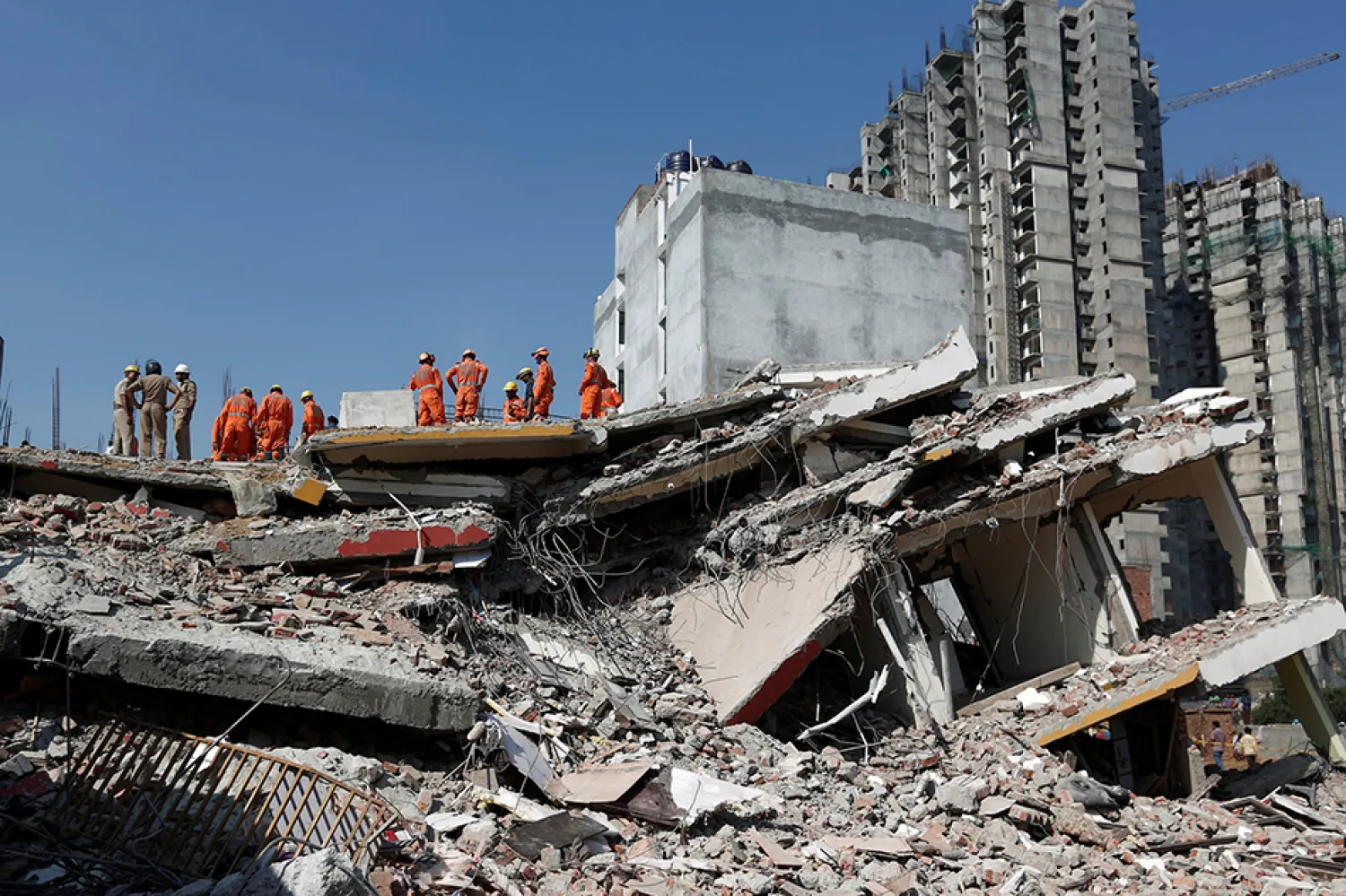 Rescue workers look for survivors amidst the rubble at the site of a collapsed residential building in Greater Noida, India. (Reuters)