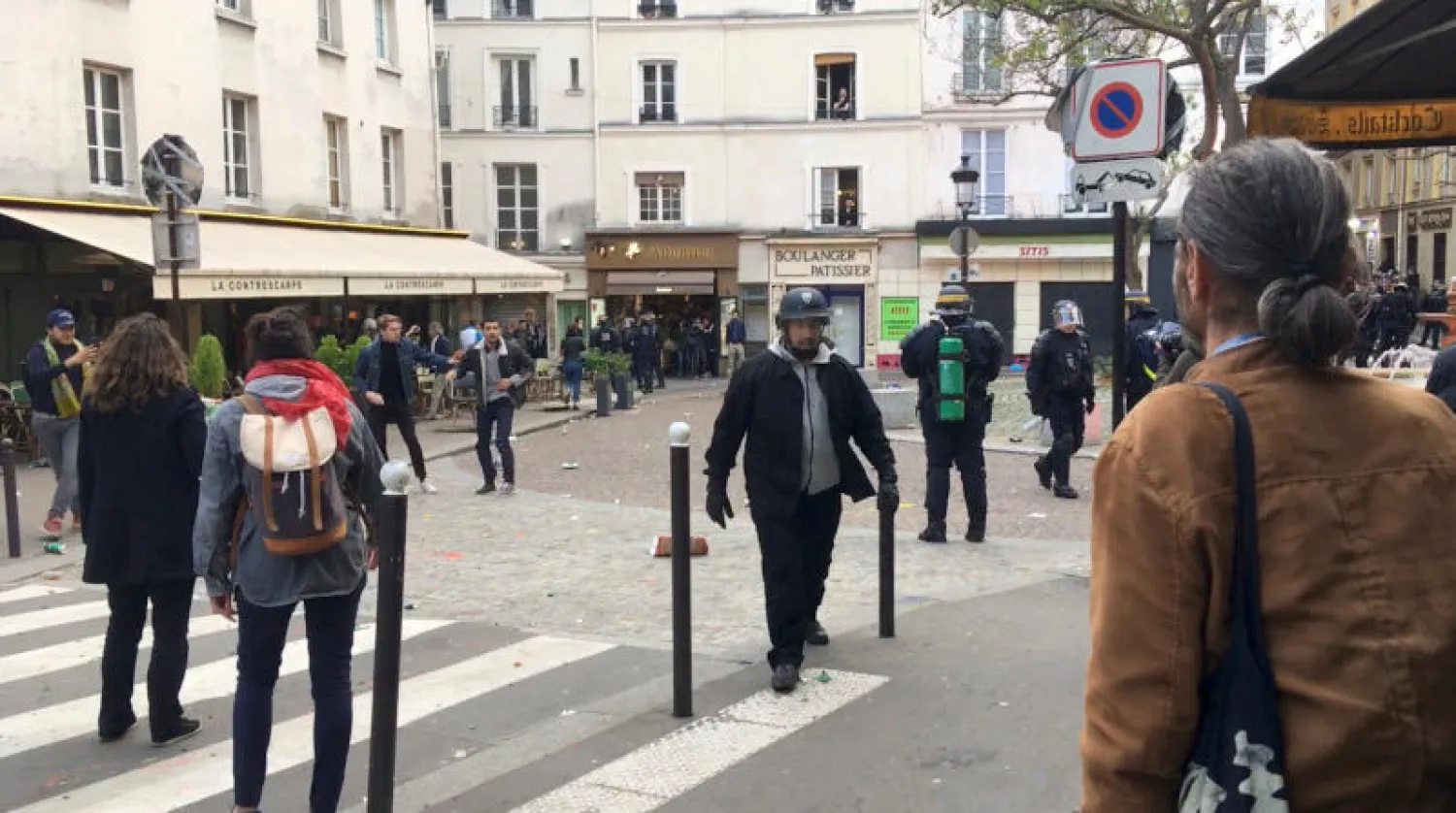 الحارس الشخصي لماكرون بعد مناوشات خلال احتجاجات اليوم العالمي للعمال بباريس (رويترز)