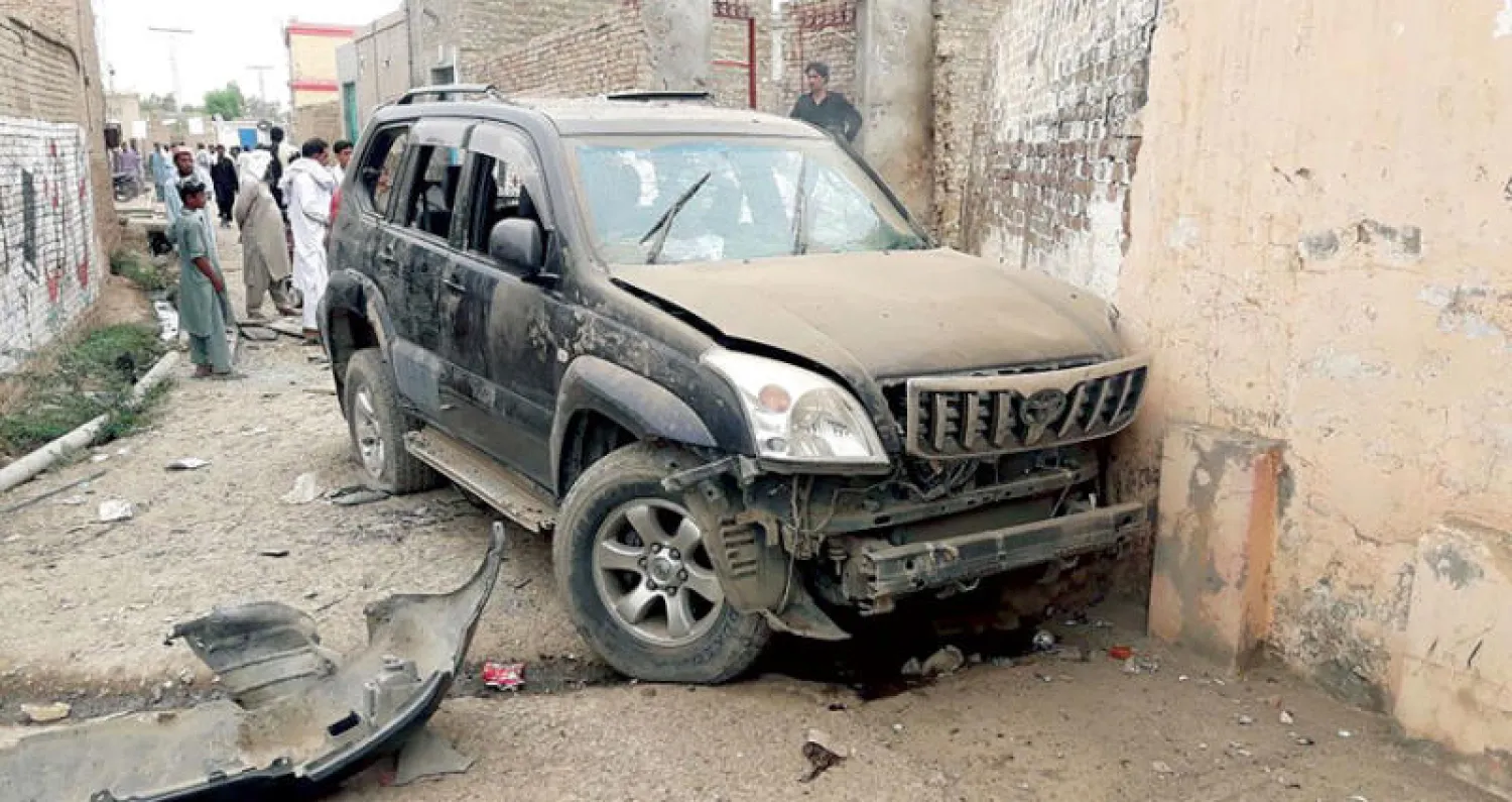 باكستانيون أمام سيارة مرشح «حركة الإنصاف» غاندابور بعد قتله في هجوم بشمال غربي البلاد أمس (أ.ف.ب)