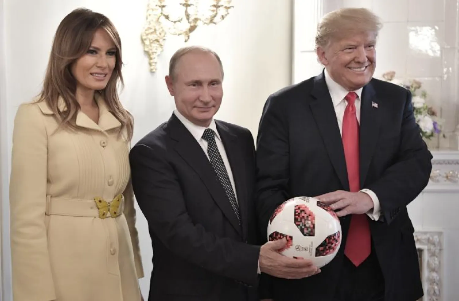 الرئيس الأميركي دونالد ترمب وزوجته ميلانيا مع الرئيس الروسي فلاديمر بوتين في صورة تذكارية مع كرة قدم كأس العالم (أ.ب)