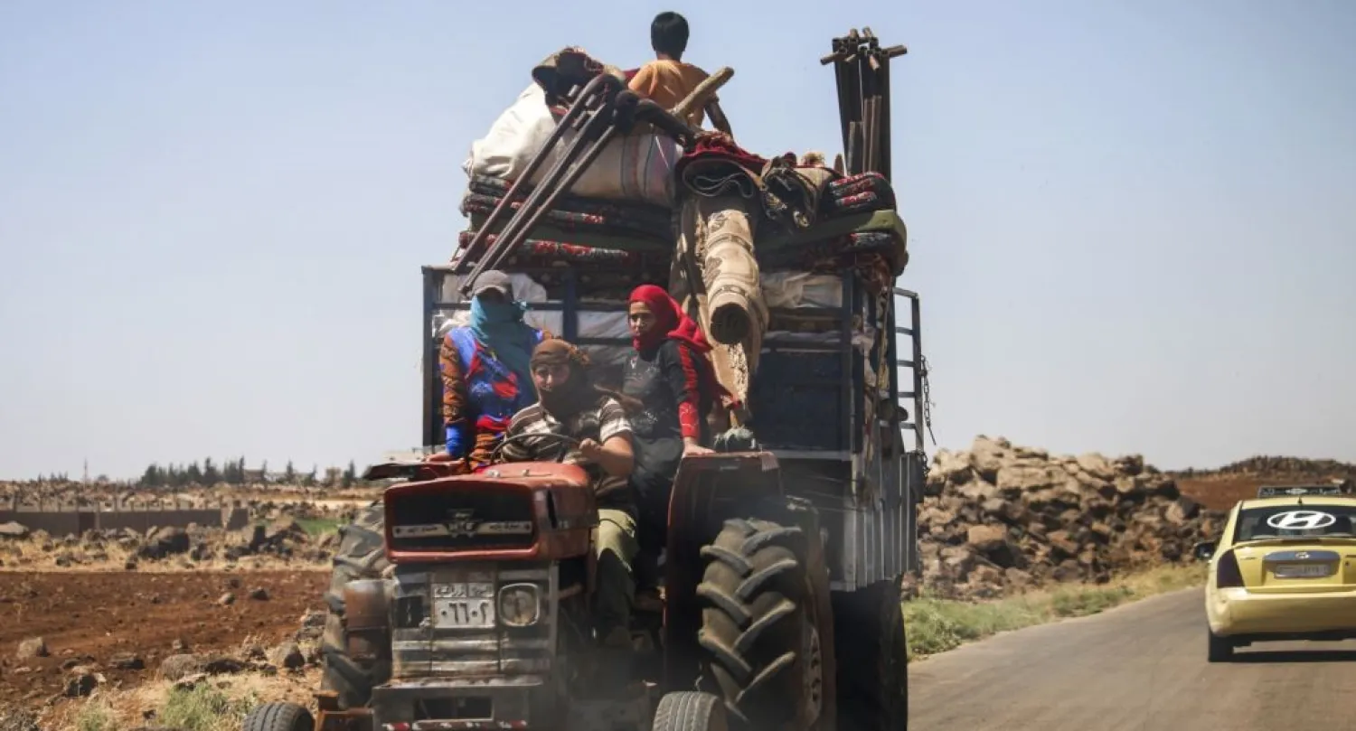 A family rides with belongings on a tractor-drawn trailer as they flee from fighting in the southern Syrian province of Daraa. (AFP)