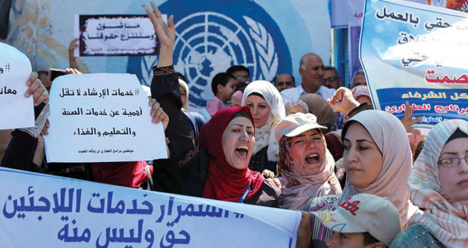 موظفون وموظفات في «أونروا» يتظاهرون أمام مقرها في غزة (أ.ف.ب)