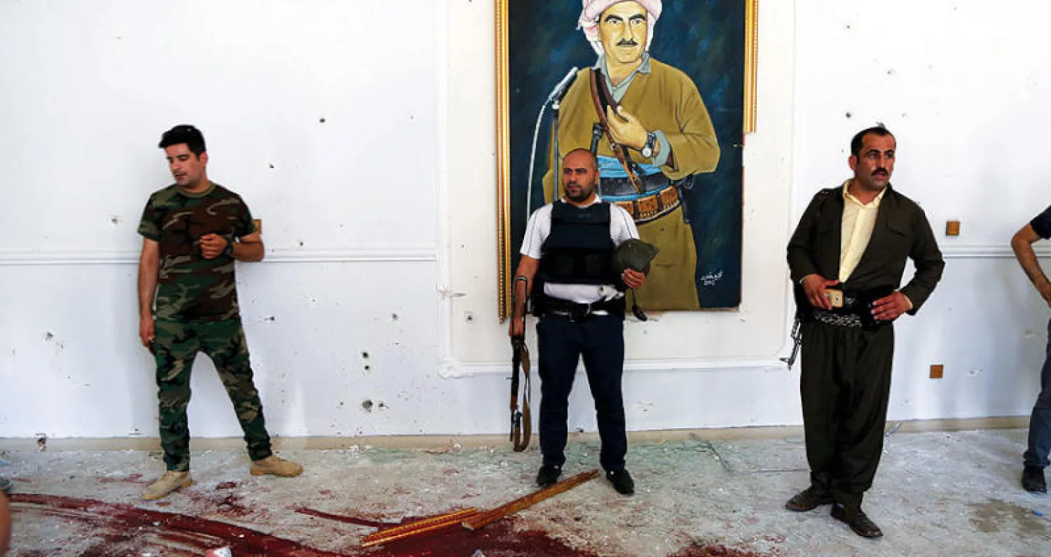 عناصر في الأمن الكردي يعاينون دماء خلفتها مواجهة مع ثلاثة مسلحين اقتحموا مبنى محافظة أربيل أمس (إ.ب.أ)