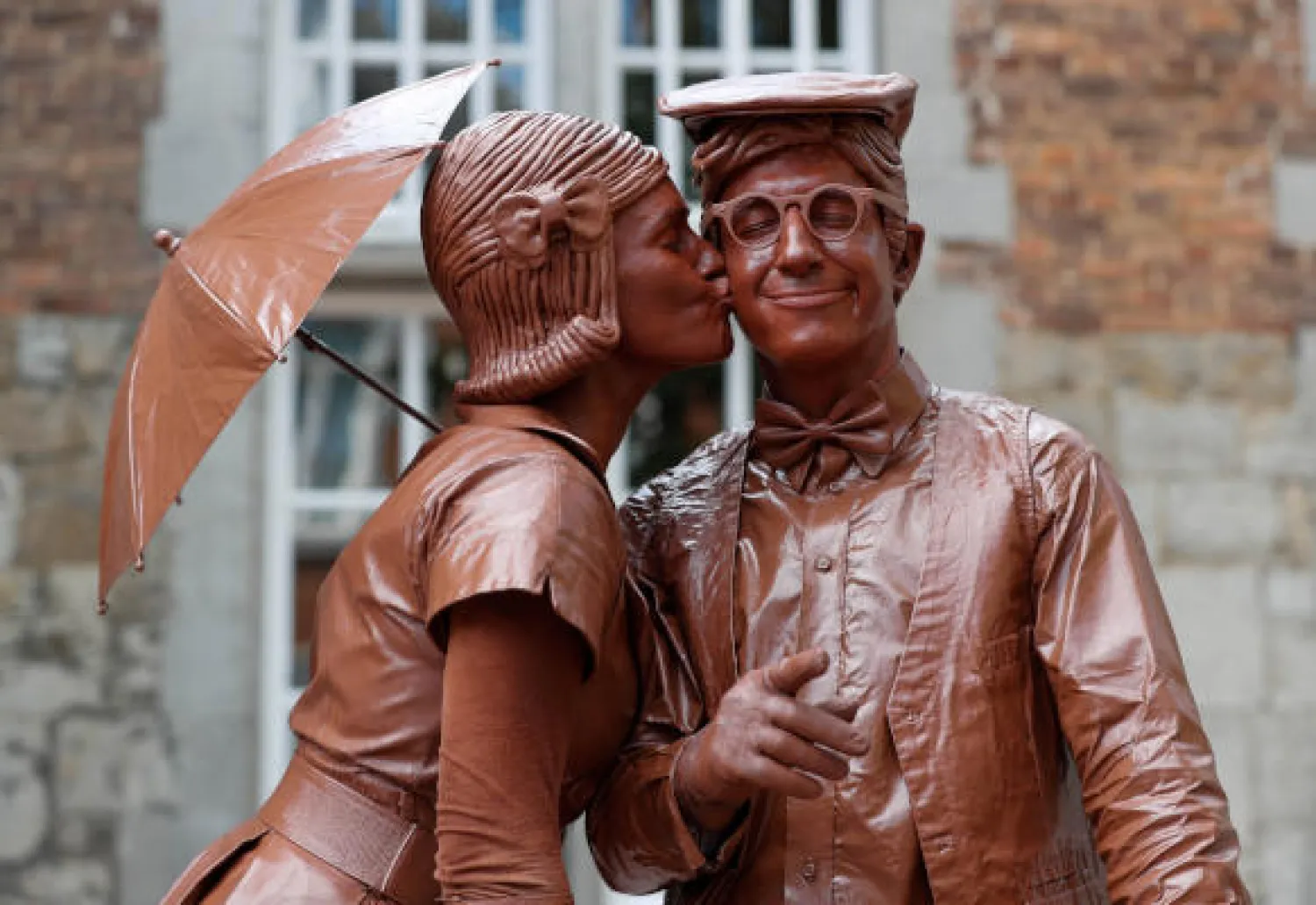 Artists called "Le couple en chocolat" take part in the festival "Statues en Marche" in Marche-en-Famenne, Belgium, July 22, 2018. REUTERS/Yves Herman