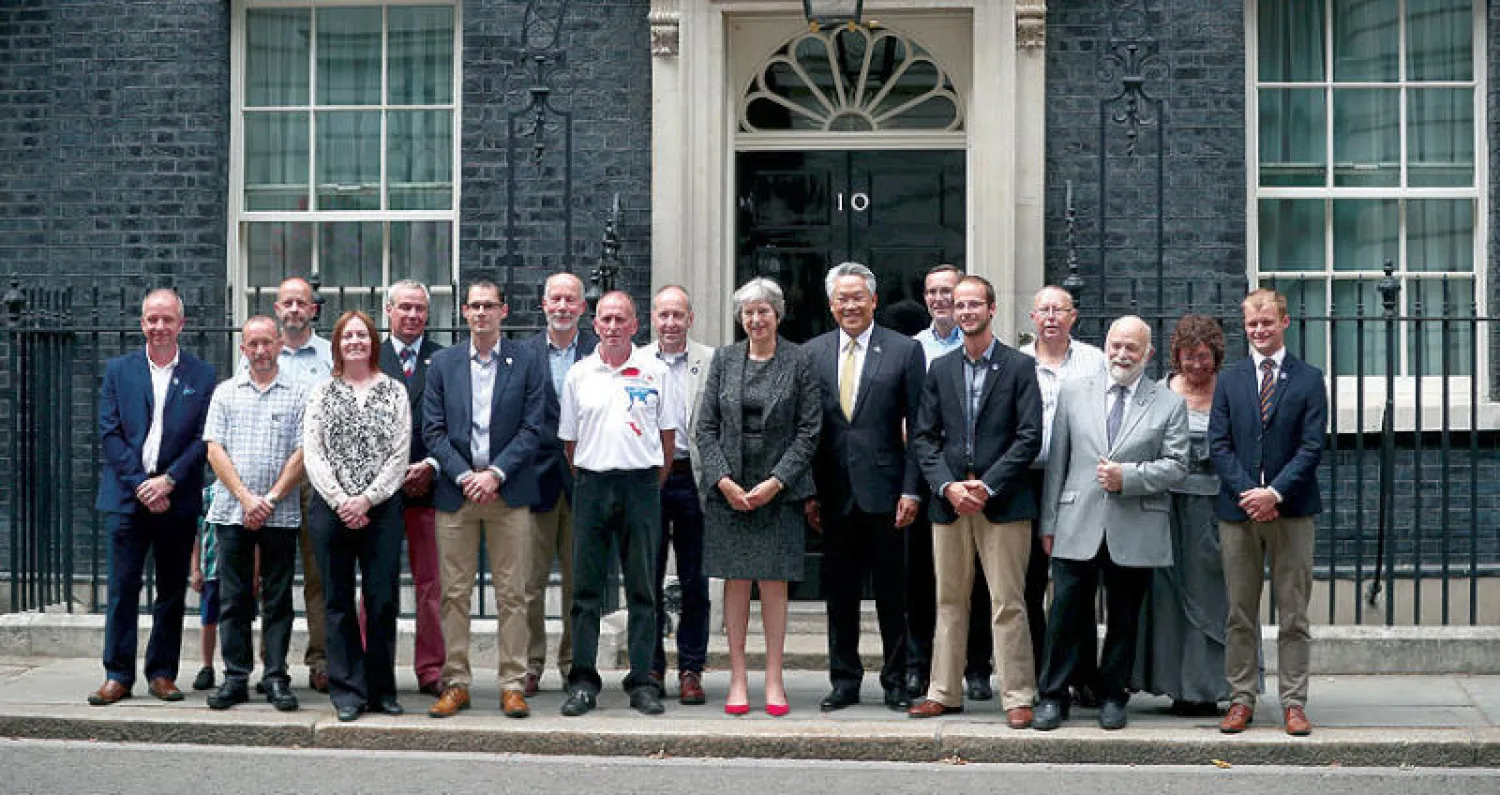 ماي لدى استقبالها في لندن أول من أمس الغواصين البريطانيين الذين ساهموا في إنقاذ «فتية الكهف» التايلانديين (رويترز)