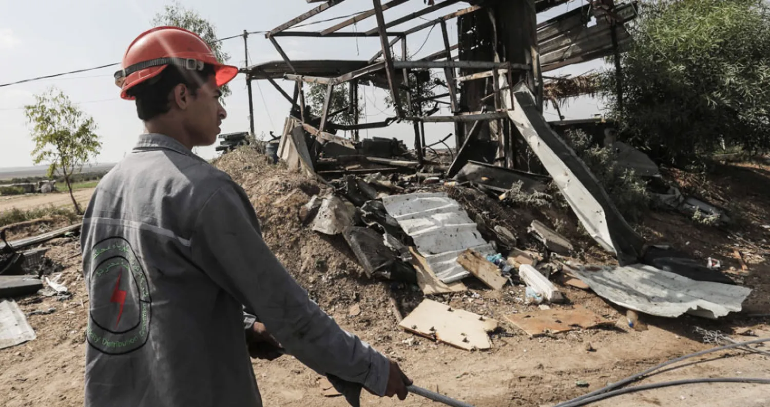 عامل كهرباء فلسطيني يتفقد الأضرار بعد قصف إسرائيلي على غزة (أ.ف.ب)