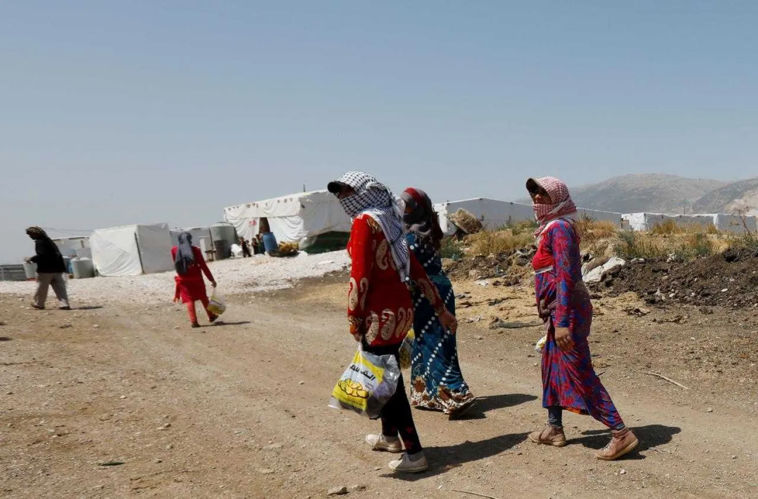 Syrian refugee women walk together at a camp for Syrian refugees near the town of Qab Elias, in Lebanon's Bekaa Valley, August 8, 2017. REUTERS/Jamal Saidi