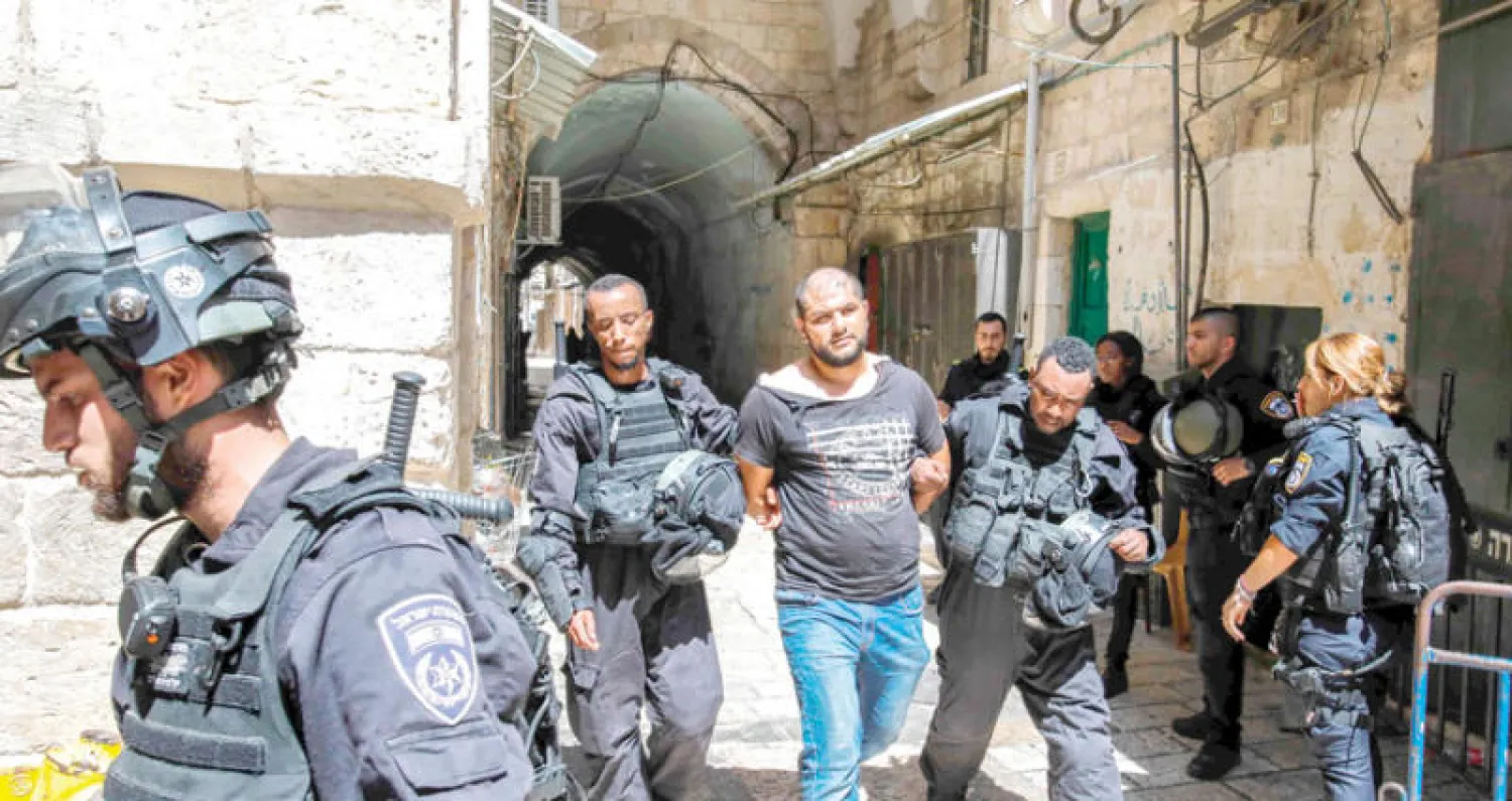 القوات الإسرائيلية تقتاد متظاهراً فلسطينياً اعتقل خلال مواجهات (أ.ف.ب)