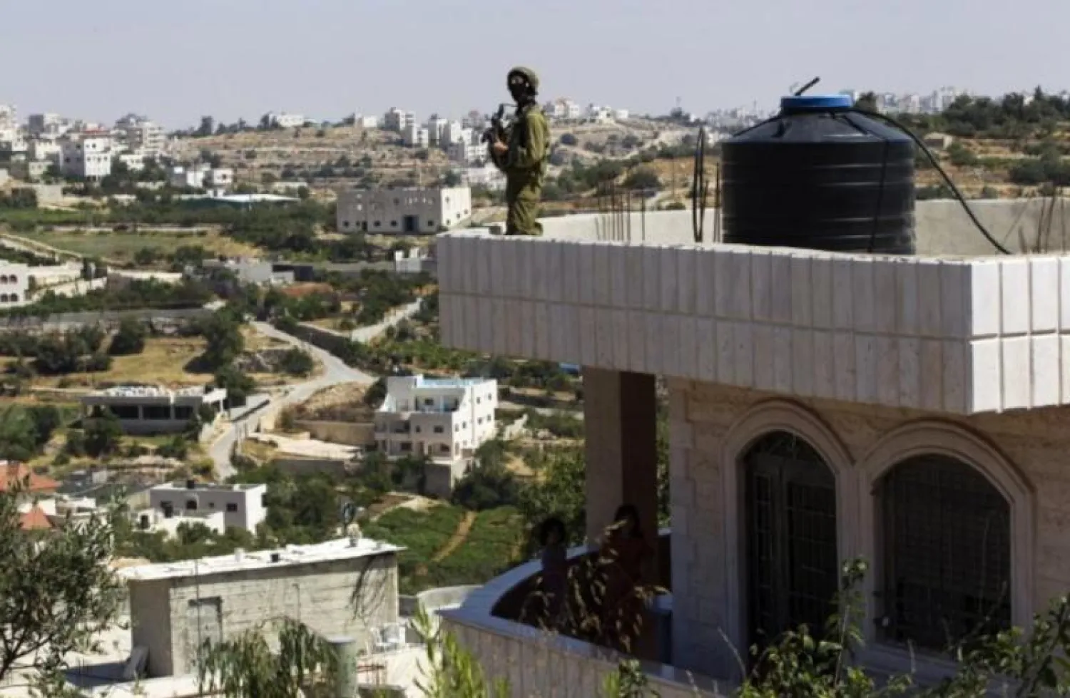 جندي إسرائيلي فوق منزل في الضفة الغربية (أرشيف - رويترز)
