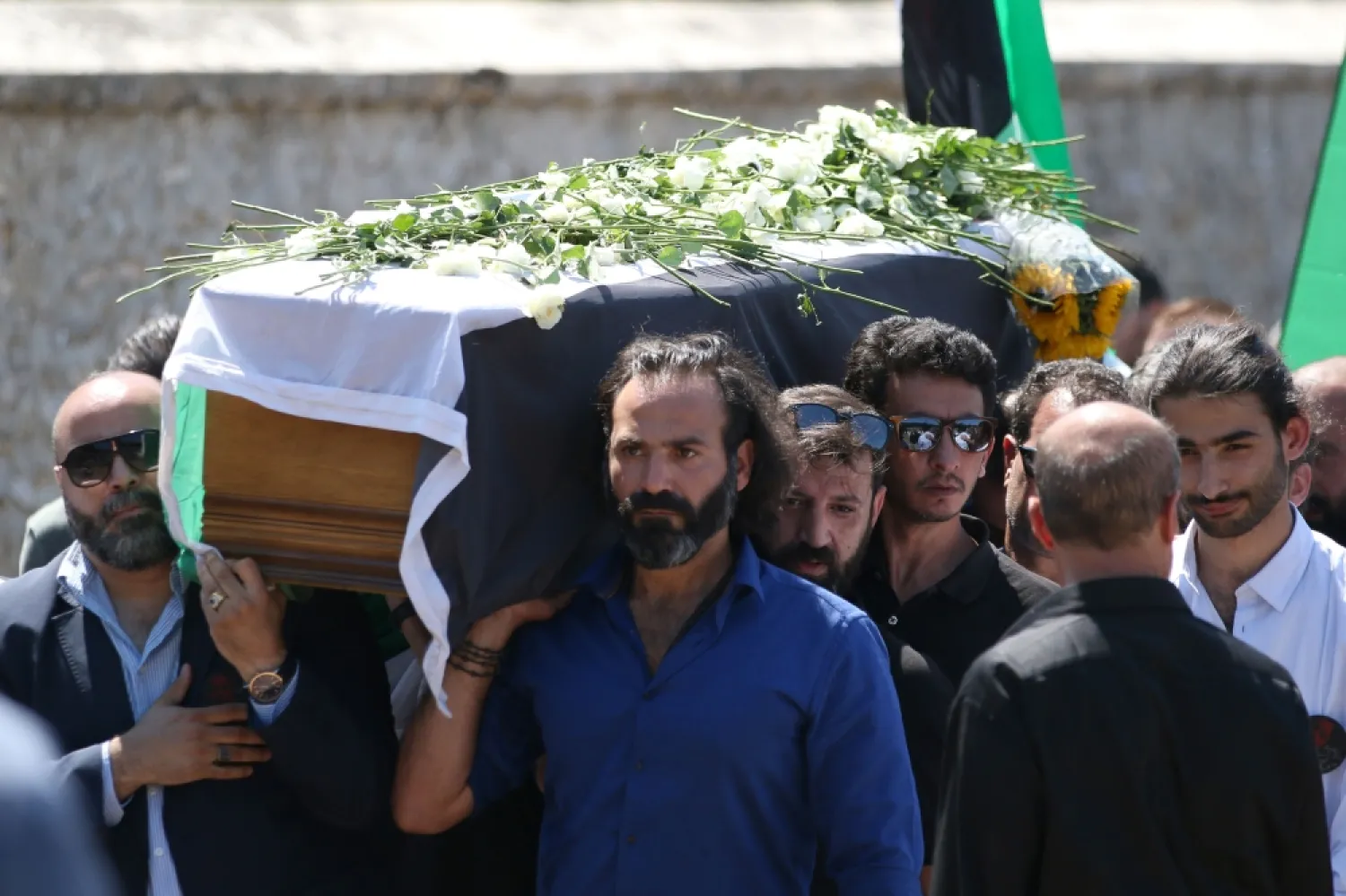 Syrian actor Jala Al-Tawil, front, helps carry the coffin of Syrian actress and democracy activist exiled by the regime, May Skaf, along with her son Joud Al-Zobi, right, in Dourdan, a southwestern Paris suburb, on Friday. — AFP

