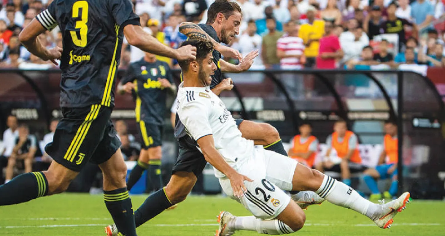 أسينسيو نجم ريال مدريد (في المنتصف) يحول الكرة إلى مرمى يوفنتوس (إ.ب.أ)