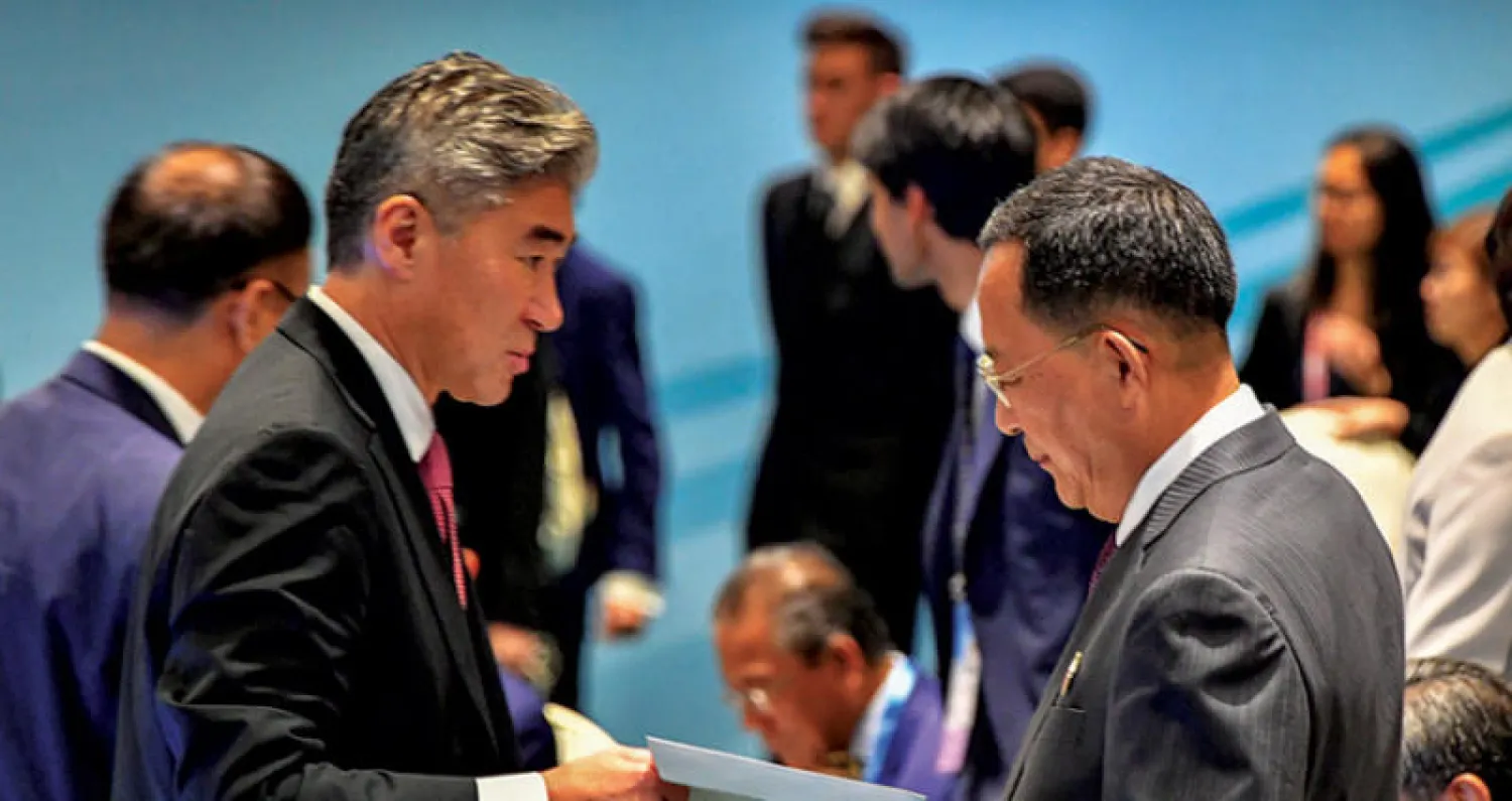 السفير الأميركي لدى الفلبين سونغ كيم يسلّم وزير الخارجية الكوري الشمالي رسالة خطية من ترمب في سنغافورة أول من أمس (رويترز)