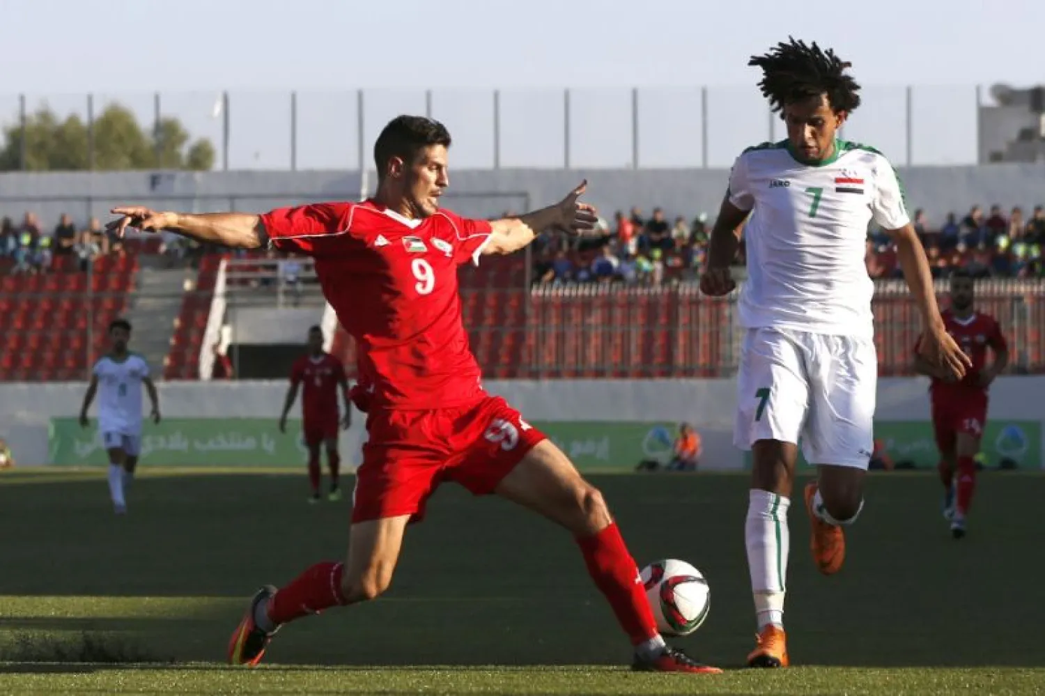 Palestine's Tamer Syam (L) and Iraq's Mazen Fyad (R) go in for a challenge during a friendly in the town of Al-Ram near Jerusalem in the occupied West Bank. (AFP)