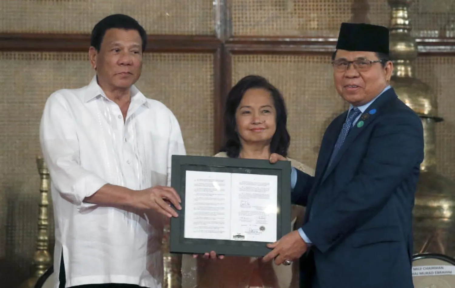 من اليسار: رئيس الفلبين رودريغو دوتيرتي ورئيسة مجلس النواب غلوريا ماكاباغال أرويو وزعيم جبهة تحرير مورو الإسلامية الحاج مراد إبراهيم لدى تقديم اتفاق السلام في مانيلا (إ ب أ)