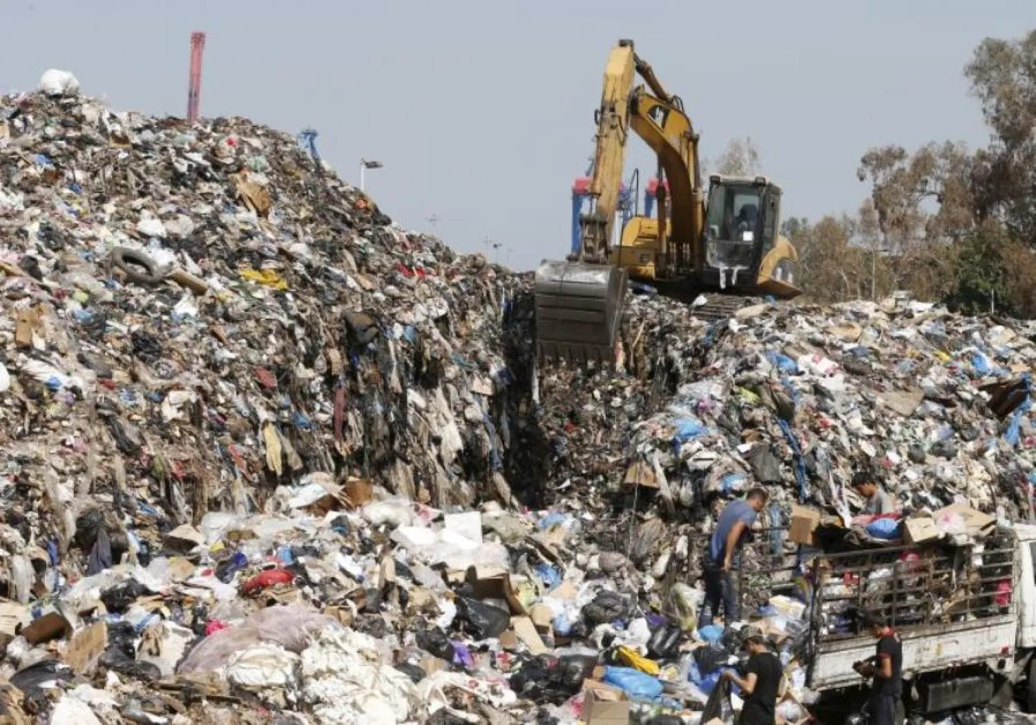 Men unload trash from a pick-up truck (File photo: Reuters)