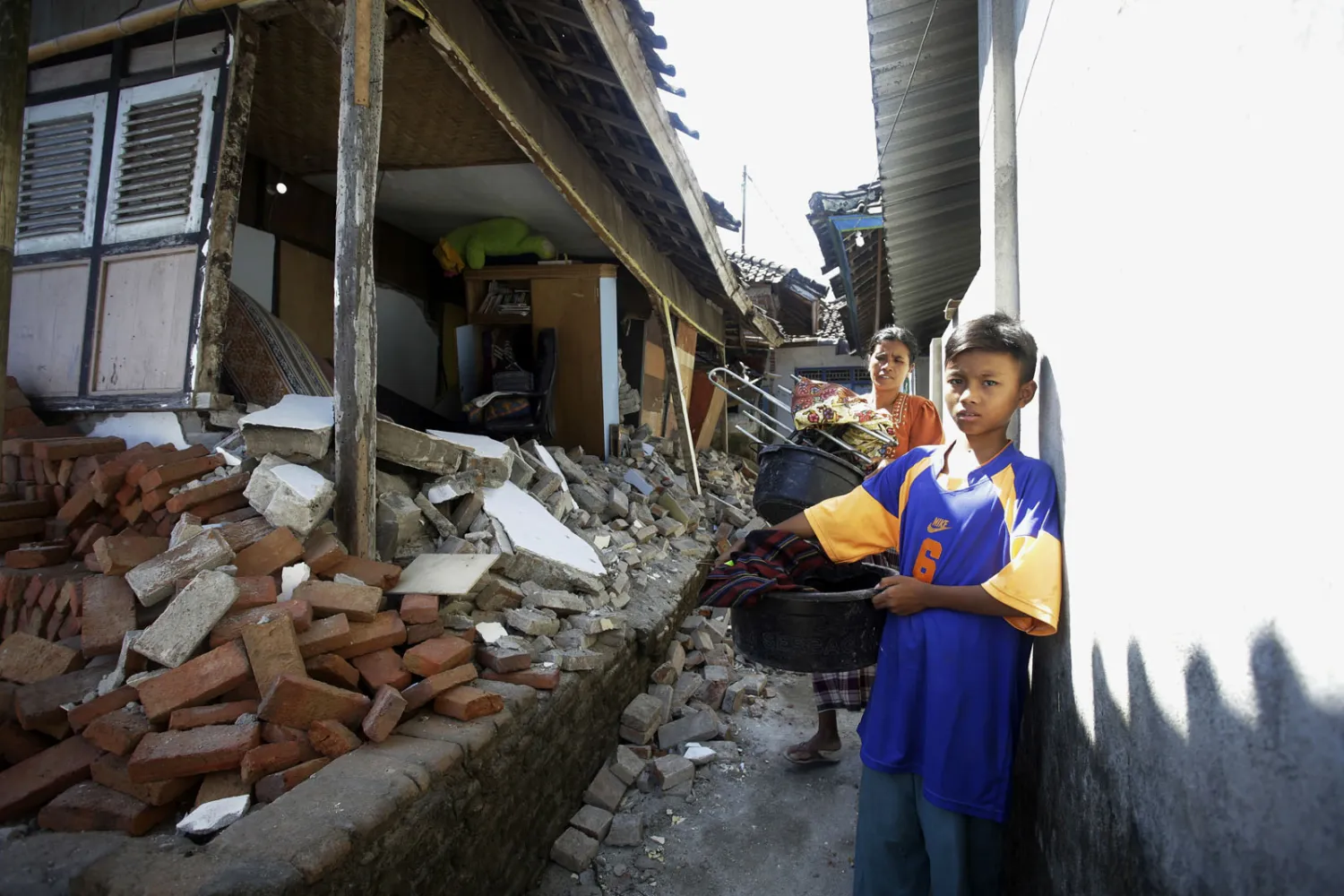 اطفال يحملون الدلاء لجمع ممتلكاتهم المفقودة