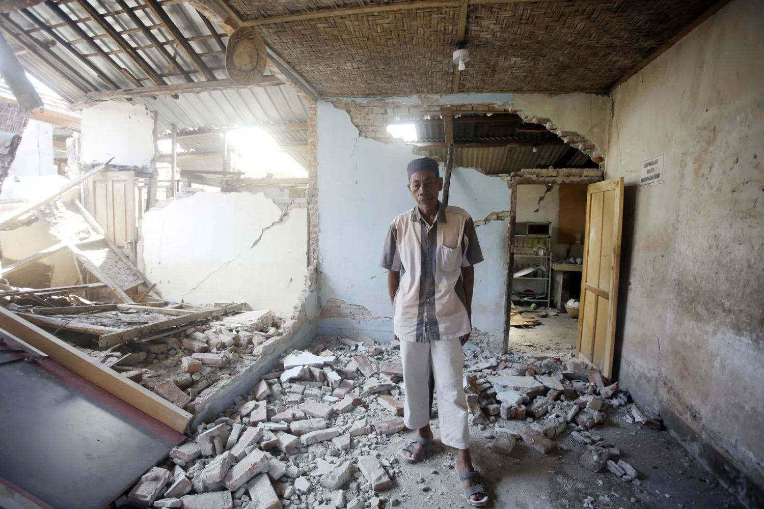 أحد الناجين من الزلزال يقف على أطلال منزله المهدم