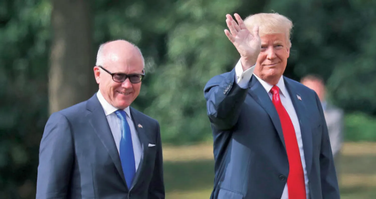 السفير الأميركي في لندن روبرت وود جونسون يمشي إلى جانب دونالد ترمب خلال زيارة الأخير للندن (أ.ب)