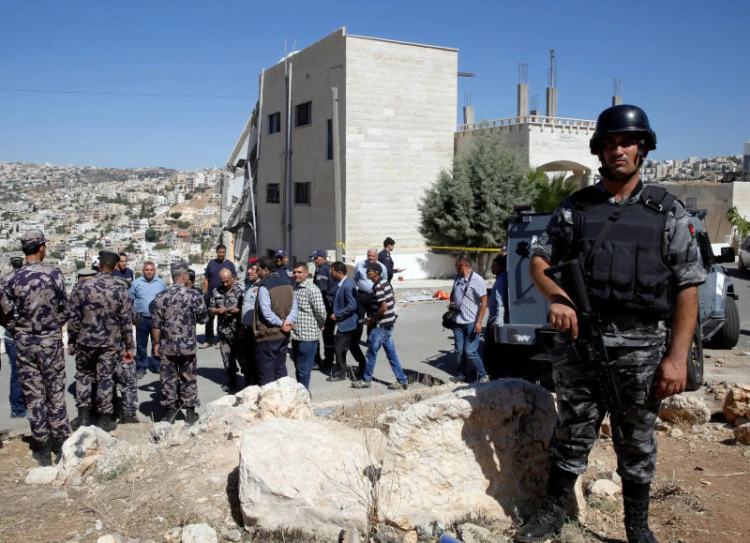 قوات الأمن الأردنية تتجمع بالقرب من المبنى الذي تحصن به الإرهابيون في مدينة السلط (رويترز)