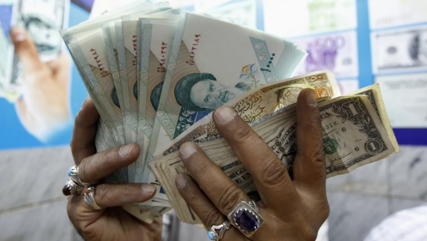 A vendor inspects Iranian rials at a currency exchange shop in Baghdad, October 4, 2012. REUTERS