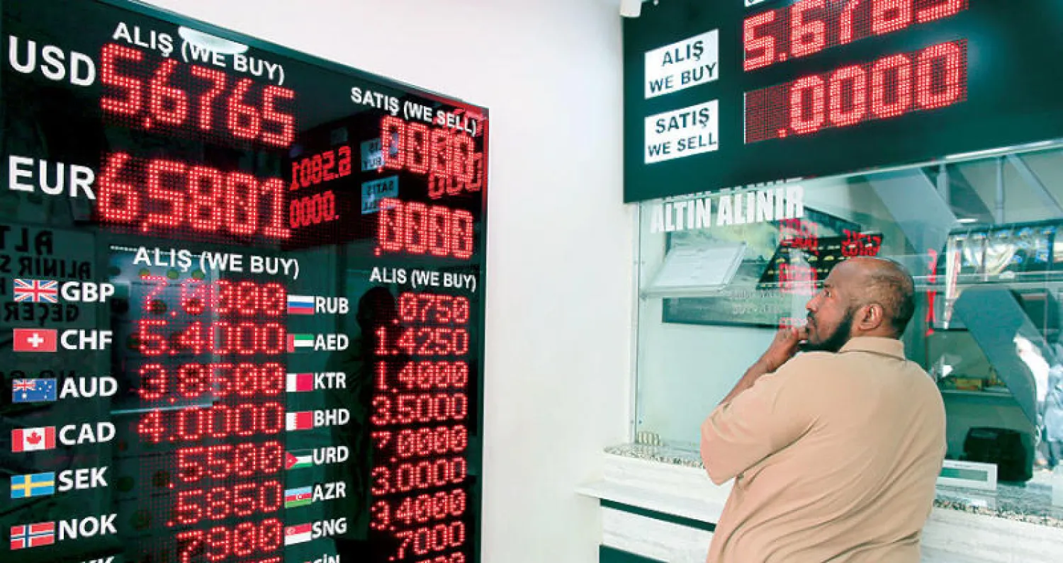 رجل ينظر إلى اسعار العملات مقارنة بالليرة التركية في اسطنبول أول من أمس (أ.ب)