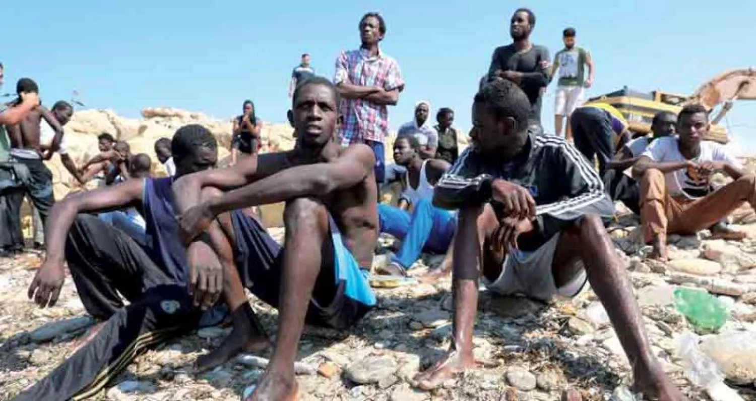 مهاجرون غير شرعيين في انتظار ترحيلهم إلى مركز لاحتجاز المهاجرين في مدينة طرابلس الليبية (رويترز)