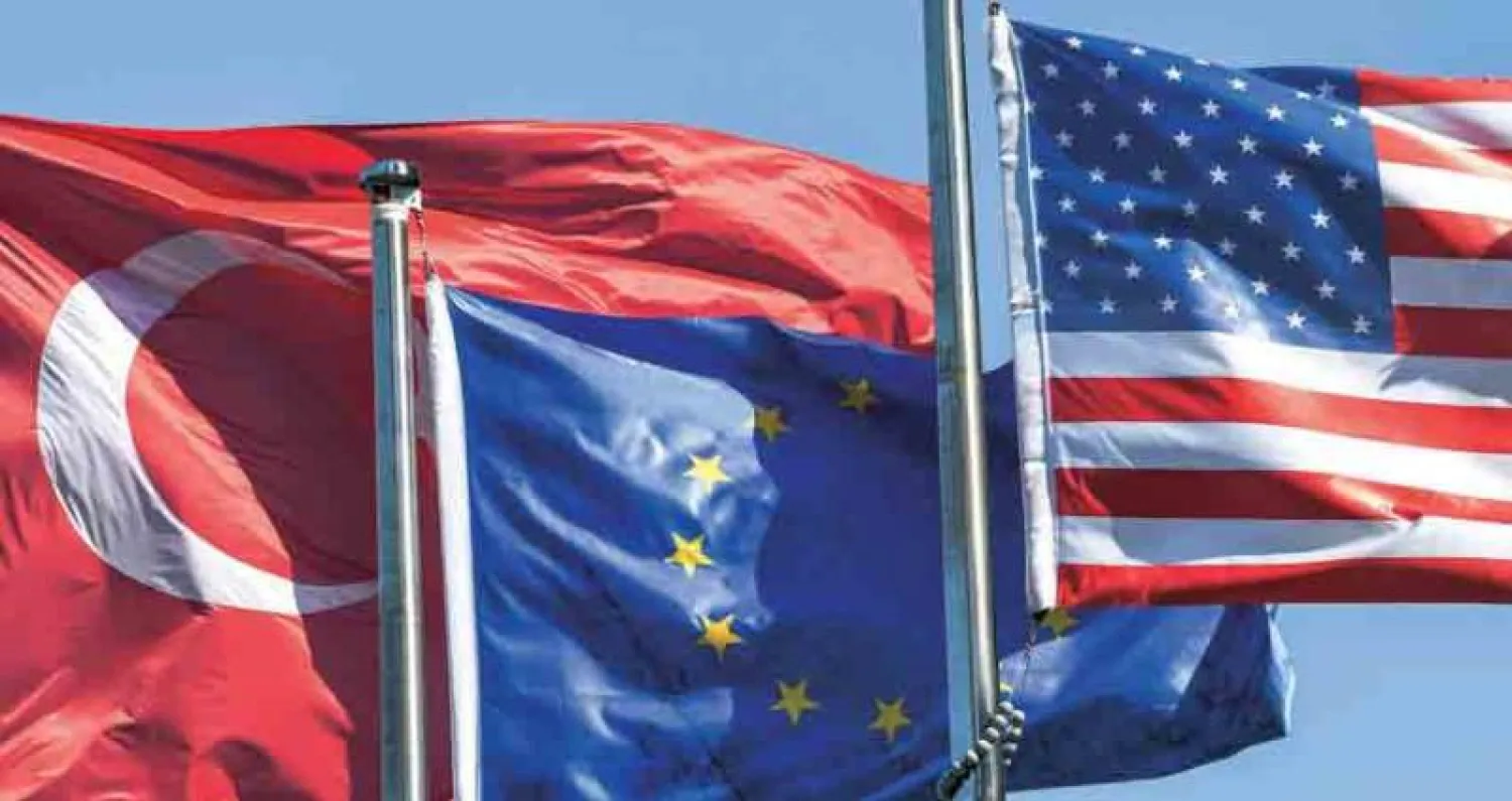 أعلام الولايات المتحدة الأميركية والاتحاد الأوروبي وتركيا في الحي المالي في إسطنبول أمس (أ.ف.ب)