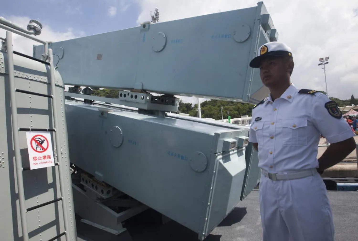 بحار يقف بجانب بطارية صواريخ على سفينة حربية صينية (إ.ب.أ)