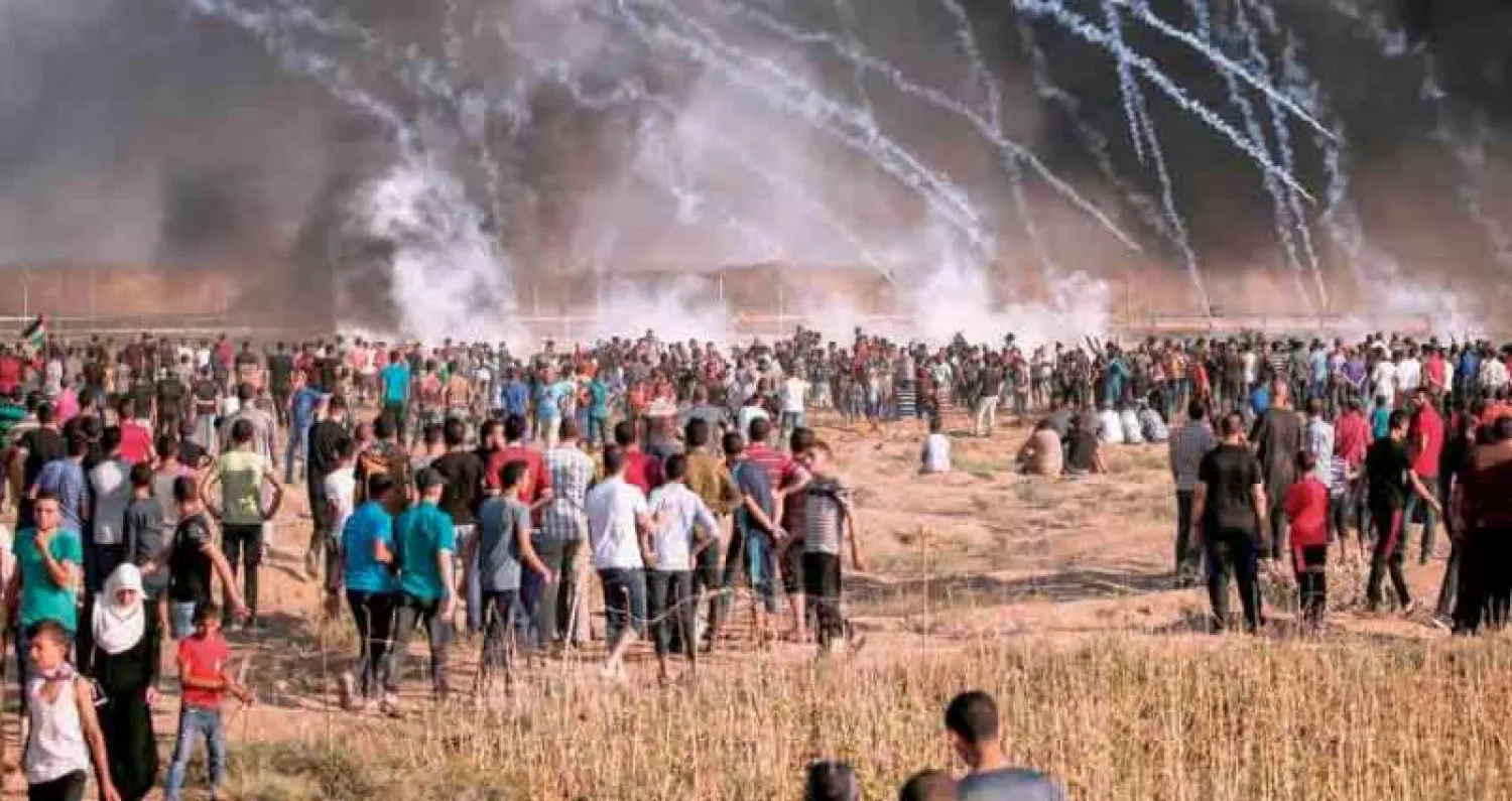 عبوات غاز مسيل للدموع أطلقتها إسرائيل تنهمر على محتجين فلسطينيين على حدود قطاع غزة أمس (أ.ف.ب)