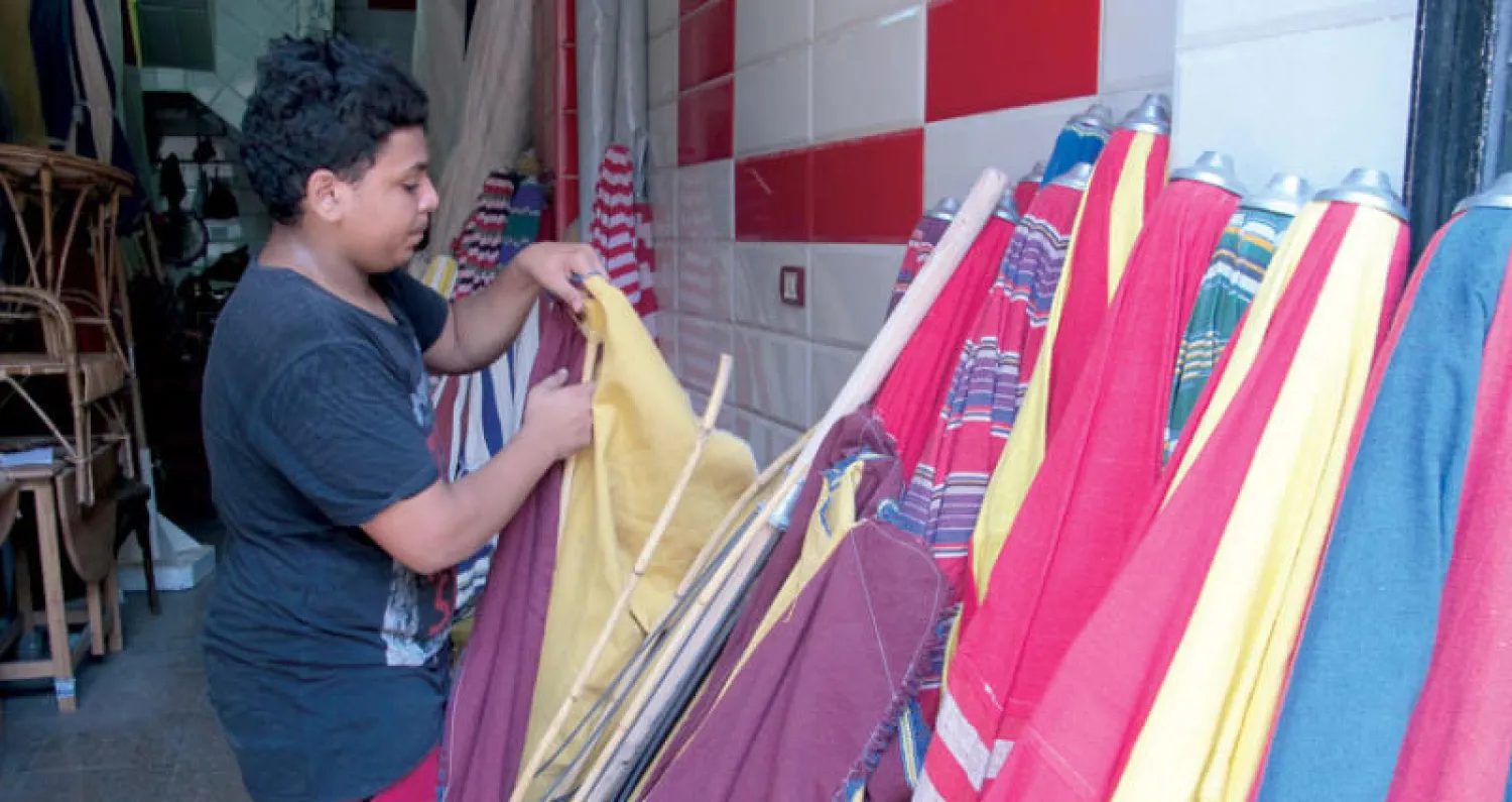 حسن أثناء صناعته للشماسي التقليدية بمنطقة تحت الربع بالقاهرة