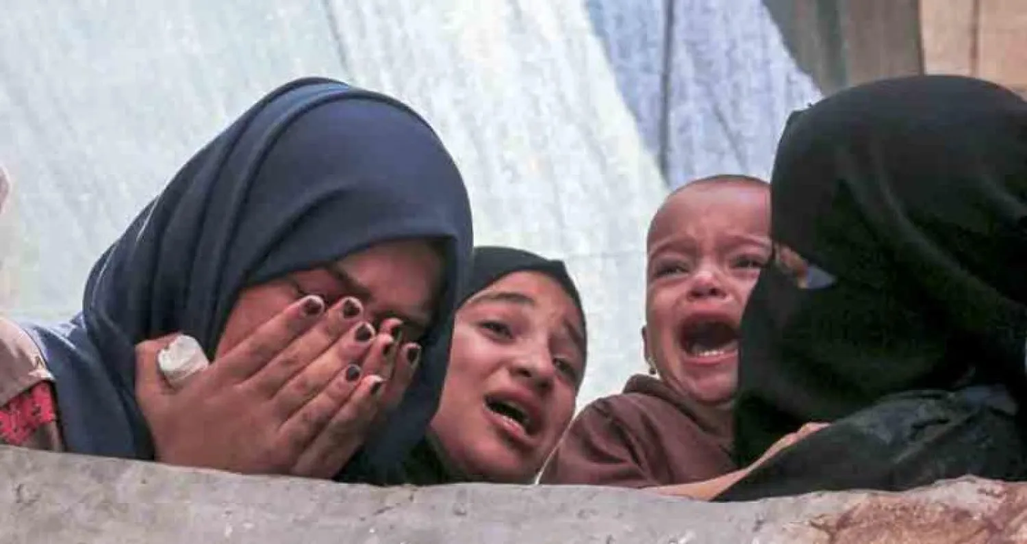 أقارب الفلسطيني سعدي معمّر (26 عاماً) الذي قُتل برصاص الجنود الإسرائيليين يوم الجمعة يبكون خلال تشييع جنازته في رفح بجنوب قطاع غزة أمس (أ.ف.ب)