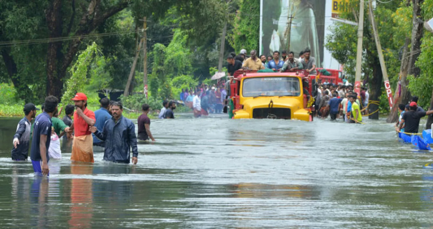 شاحنة تحمل مجموعة من الأشخاص في طريق غمرته مياه السيول في ثريسور في جنوب ولاية كيرالا الهندية (أ.ب)