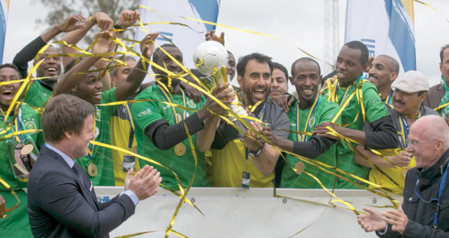 لاعبو الأخضر خلال تتويجهم باللقب العالمي ويبدو المدرب عبد العزيز الخالد («الشرق الأوسط»)