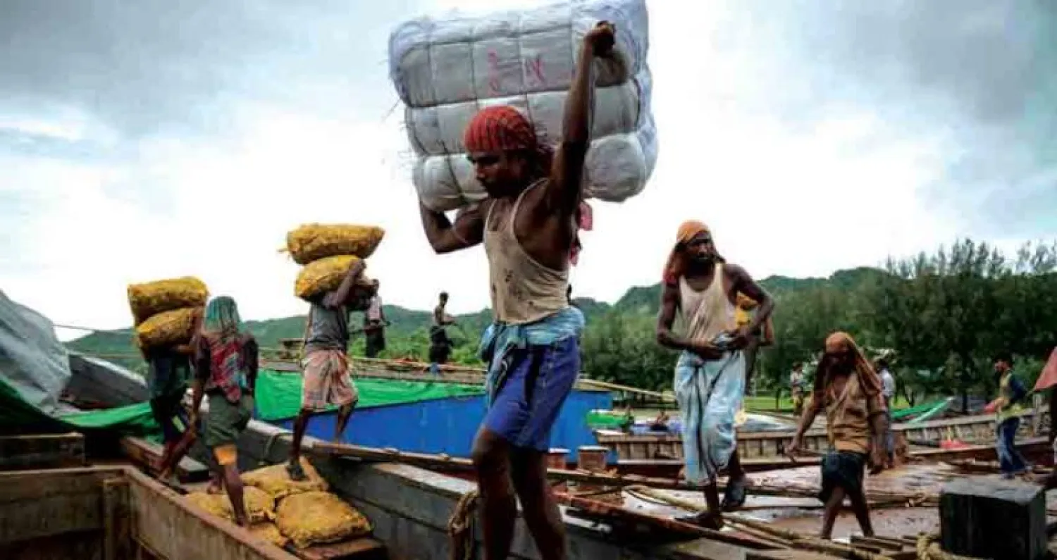 عمال من الروهينغا ينقلون أكياساً من الزنجبيل في ميناء تكناف الأسبوع الماضي (أ.ف.ب)