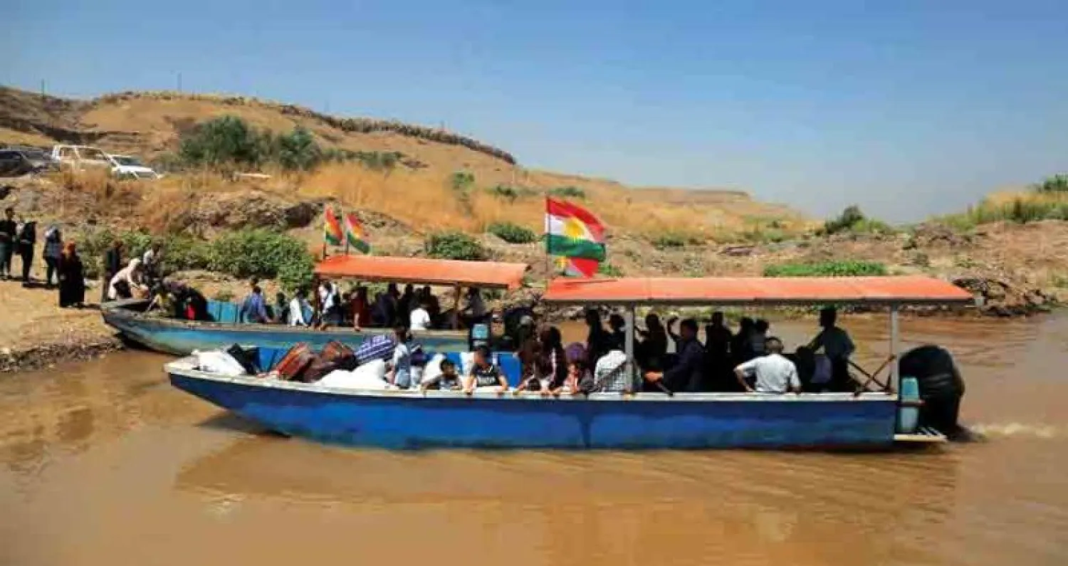 عائلات كردية من العراق تجتاز معبر سيمالكا النهري إلى سوريا لقضاء عطلة الأعياد مع الأقرباء (أ.ف.ب)